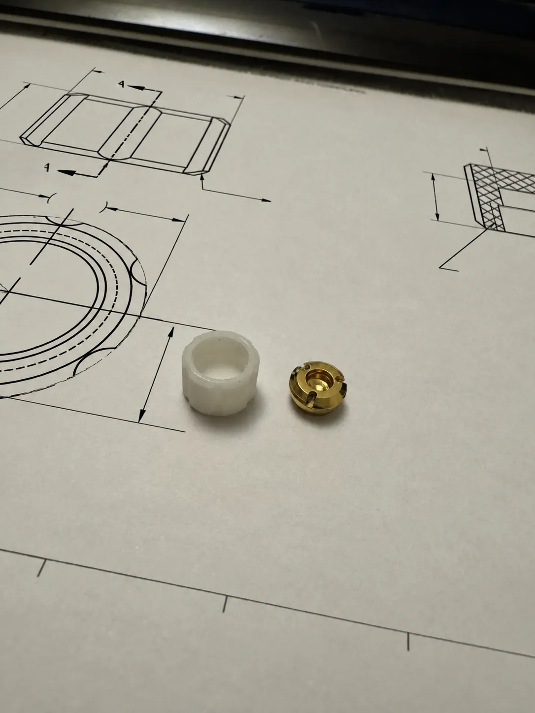 Finished white engineered component photographed on its technical drawing